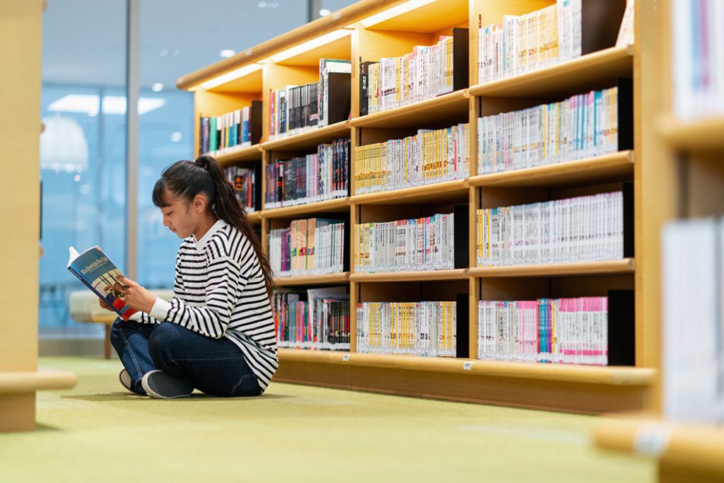 young girl reading in school library